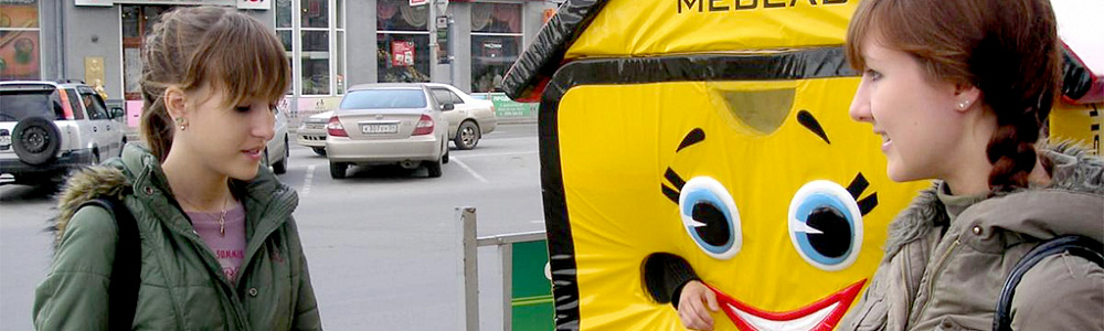 Промоутер в специальном костюме раздает листовки