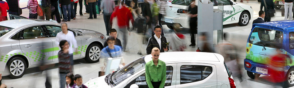 Помощница у стенда автомобилей